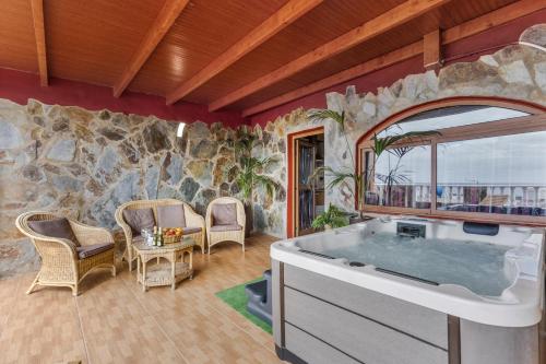 a bathroom with a tub in a room with a stone wall at Chabela's Penthouse in Lajita