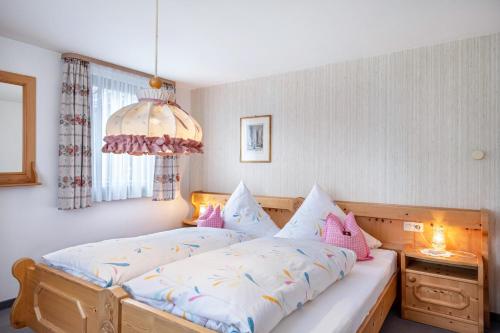 a bedroom with a large bed with a chandelier at Rathäusle in Titisee-Neustadt