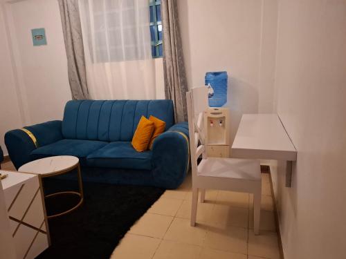 a living room with a blue couch and a table at Bright Homes in Eldoret
