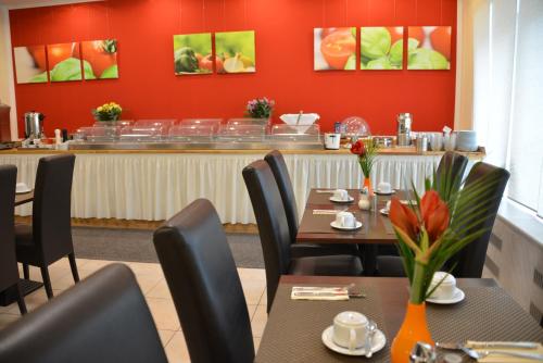 a restaurant with tables and chairs and a counter at Hotel Italia in Munich