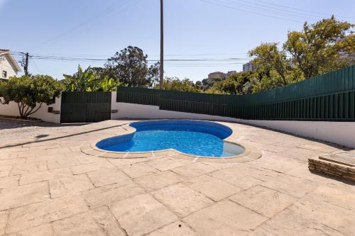 a small pool in a patio with a fence at Vivenda De São Marcos in Cacém