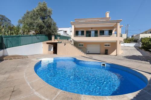 a swimming pool in front of a house at Vivenda De São Marcos in Cacém