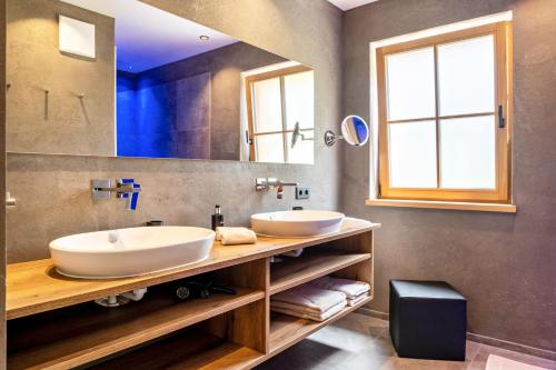 a bathroom with two sinks and a large mirror at Hoamat Schlosshof in Völs am Schlern