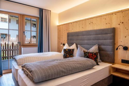 a bedroom with two beds and a balcony at Hoamat Schlosshof in Völs am Schlern