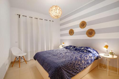 a bedroom with a blue bed and striped walls at Royal Cabanas Golf 81 in Conceição
