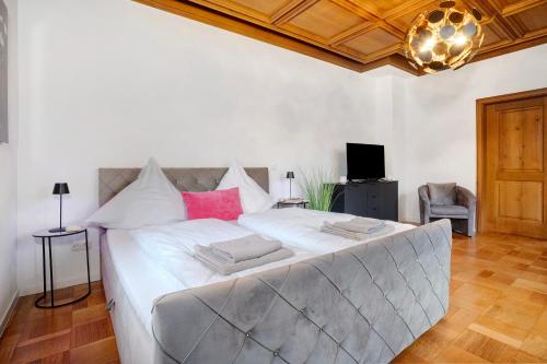 a large bed with white sheets and pink pillows at Goldberg in Grünstadt
