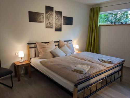 a bedroom with a bed with two lamps and a window at Fewo New Oberdorf in Fautenbach