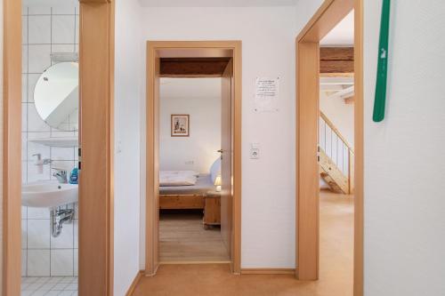 a hallway with a sink and a bed in a room at Haus Hilebrand in Kressbronn am Bodensee