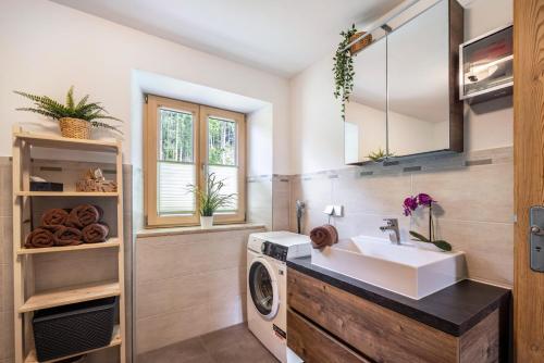 a bathroom with a sink and a washing machine at Martin´s Alm in Friesenried