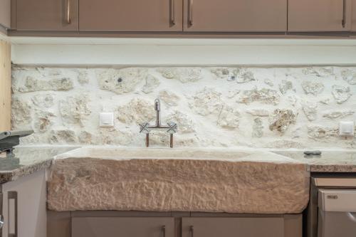 a kitchen counter with a stone wall with a sink at Maniaveta's House in Exanthia