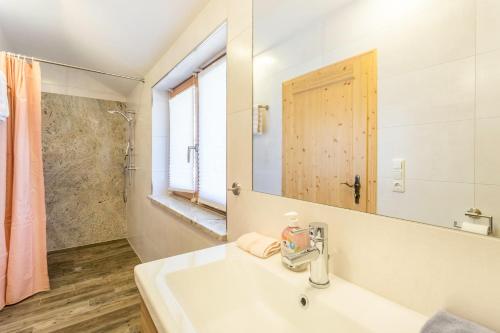 a white bathroom with a sink and a mirror at Ferienwohnung Rosenquarz in Mittenwald