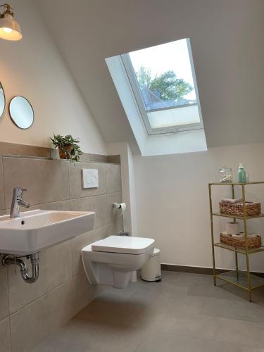 a bathroom with a sink and a toilet and a skylight at Meerzeit in Eckernförde