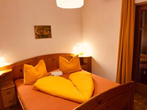 a bed with yellow pillows on top of it at Residence Zirmer Wohnung Sonne in Castelrotto