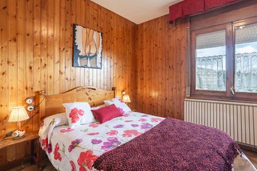 a bedroom with wooden walls and a bed with a purple blanket at Can Mussol in Sant Hilari Sacalm