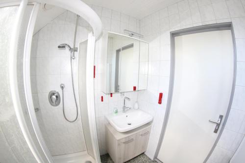 a white bathroom with a shower and a sink at Ferienhaus 109 - Seepark Kirchheim in Kirchheim