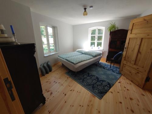 a bedroom with a bed and a wooden floor at Ferienhaus Melkerhaus in Neetzendorf