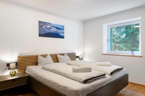 a large bed in a white room with a window at Apartment Anna in Soprabolzano