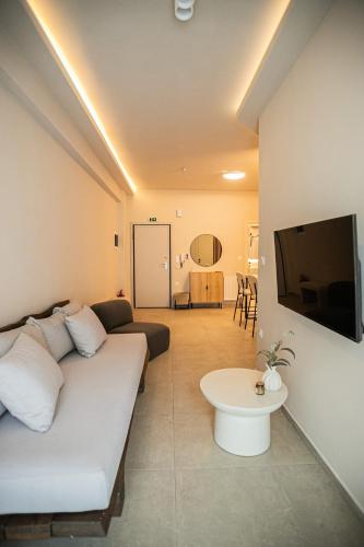 a living room with a couch and a flat screen tv at Sofia's central suite in Alexandroupoli