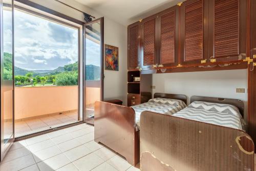 a bedroom with a bed and a large window at Villa Patrizia in Castelsardo