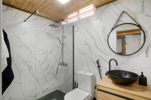 a bathroom with a toilet and a sink and a mirror at Casa Cueva in Teror