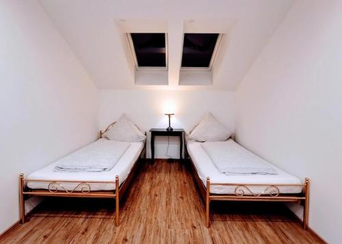 two beds in a room with a table and two windows at Ludwig der xvi in Schwandorf in Bayern