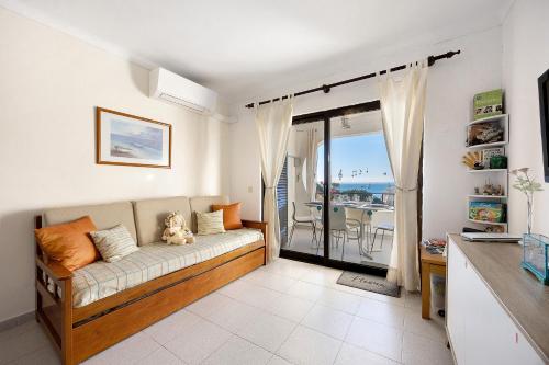 a living room with a couch and a balcony at Apartamento Mar-colina-sol in Carvoeiro