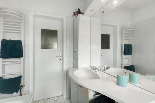 a white bathroom with a sink and a tub at Ferienwohnung Ruhepol, 75qm in Vellmar