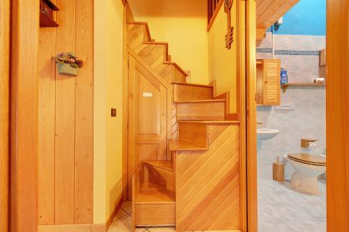 a wooden staircase in a bathroom with a toilet at Casa Aliza - Duplex Alpino in Pieve di Bono