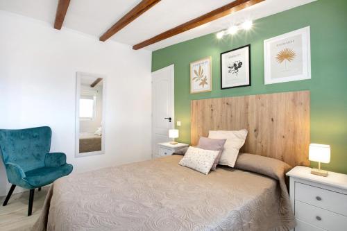 a bedroom with a bed and a blue chair at El chiringuito in Candelaria