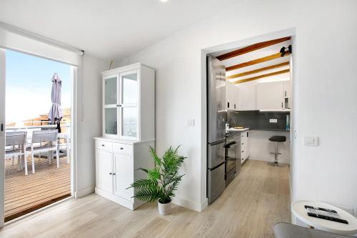 a kitchen and dining room with white cabinets and a plant at El chiringuito in Candelaria