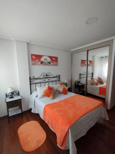 a bedroom with a large bed with an orange blanket at O Son in Cee