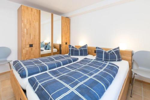 a bedroom with two beds with blue and white pillows at Ferienwohnung Lauser Ug in Herdwangen-Schönach
