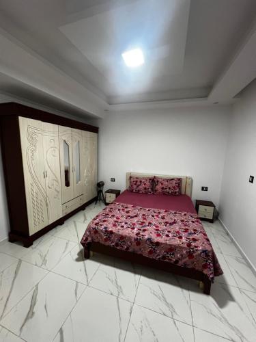 a bedroom with a bed in a white room at Villa charme in Awlād ‘Umar