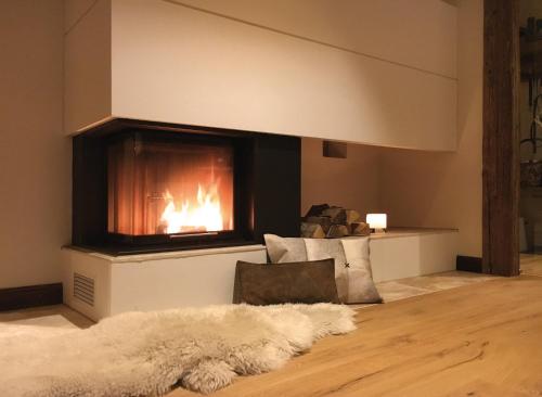 a living room with a fireplace and a fur rug at Ahorn Chalet Mittelberg in Mittelberg