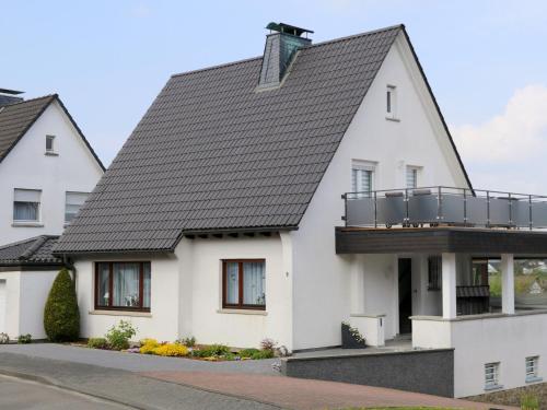 a white house with a black roof at Ferienwohnungen Schimsheimer Rhode in Olpe