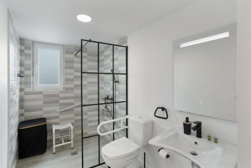 a white bathroom with a toilet and a sink at El Alpendre in Moya