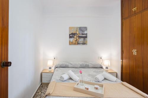 a bedroom with a bed with two night stands and two tables at Llúria 51 in Oliva