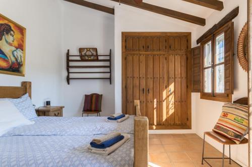 a bedroom with a bed and a sliding door at Finca el Cerrillo Competa in Cómpeta