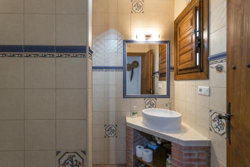 a bathroom with a sink and a mirror at Finca el Cerrillo Competa in Cómpeta