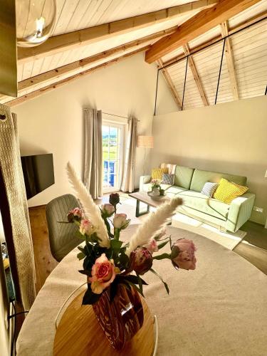 a living room with a vase of flowers on a table at Aubrac-Biohof Königshainer Berge in Königshain