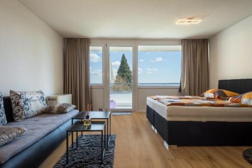 a hotel room with a bed and a couch at Appartment Panoramablick in Oberteuringen