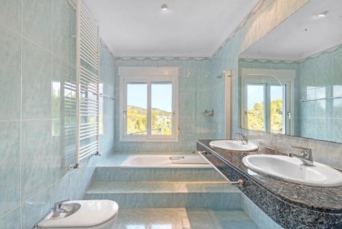a bathroom with two sinks and a tub at Bohemia in Jávea