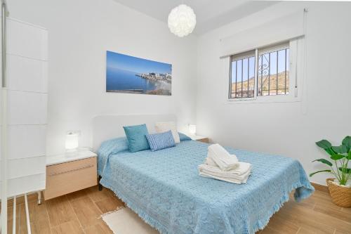a bedroom with a bed and a desk and windows at Casa Rural El Granado in Nerja