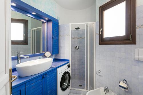 a bathroom with a sink and a washing machine at Appartamento in centro Sole e Mare in Porto San Paolo