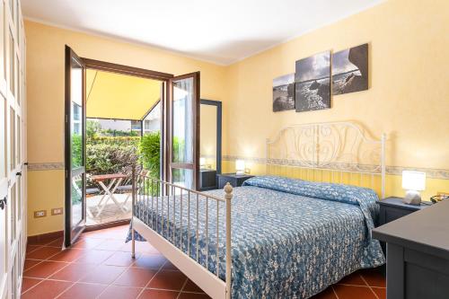 a bedroom with a bed and a balcony at Appartamento in centro Sole e Mare in Porto San Paolo