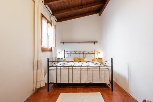 a bedroom with a metal bed in a room at Agata House in Muravera