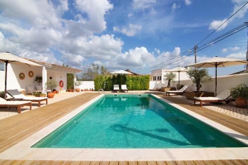 a pool with a wooden deck and a villa at Casa de Benafim 51 in Benafim