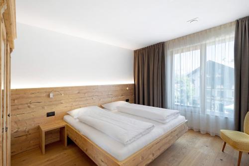 a bedroom with a bed and a large window at Villa Kriendl Nr 4 Dreifinger in Valdaora