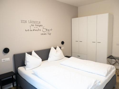 a bedroom with a bed with white sheets and pillows at Apartment Manuela in Merano