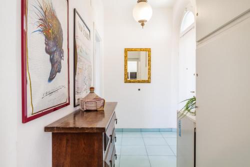a hallway with white walls and a table and a mirror at Appartamenti Remota in Castiglione della Pescaia